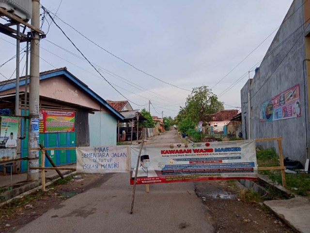 Banner dan papan membentang menutup akses masuk Gang Kenanga III RT 06 Kelurahan Way Kandis Kecamatan Tanjung Senang Bandar Lampung, Rabu (2/9) | Foto : Sidik Aryono/Lampung Geh