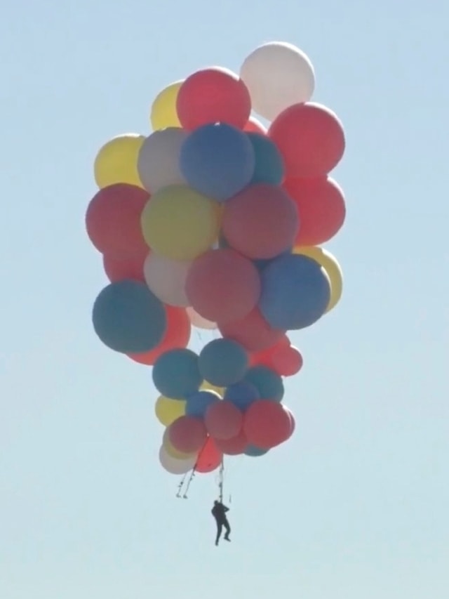 Aksi eskstrem David Blaine tergantung pada sejumlah balon di Arizona, Amerika Serikat.  Foto: David Blaine/via REUTERS