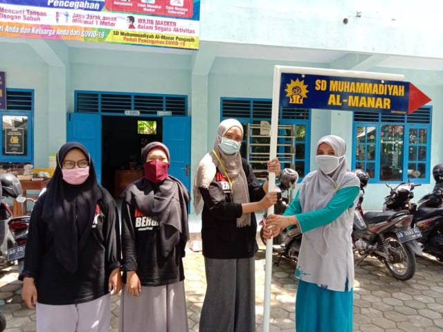 Penyerahan plang penujuk jalan Tim KKN Muhammadiyah Mengajar 002 untuk SD Muhammadiyah Al-Manar 