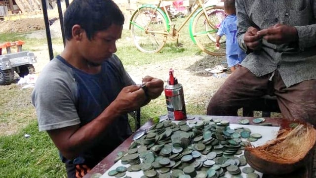 Penggali kubur di Aceh, menemukan uang logam kuno. Foto: Dok. Istimewa