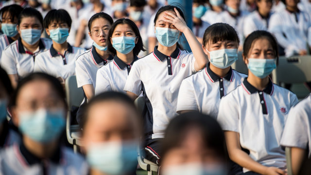 Sejumlah siswa sekolah dasar menghadiri kelas pada hari pertama semester baru di Wuhan, Hubei, China, Selasa (1/9). Foto: STR/AFP