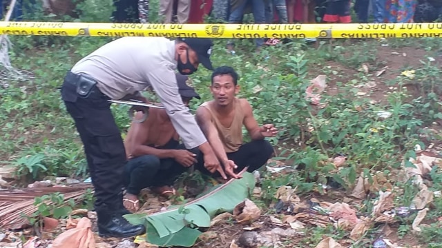Polisi saat melakukan olah TKP penemuan mayat bayi di tumpukan sampah. Foto: Istimewa/kendarinesia.