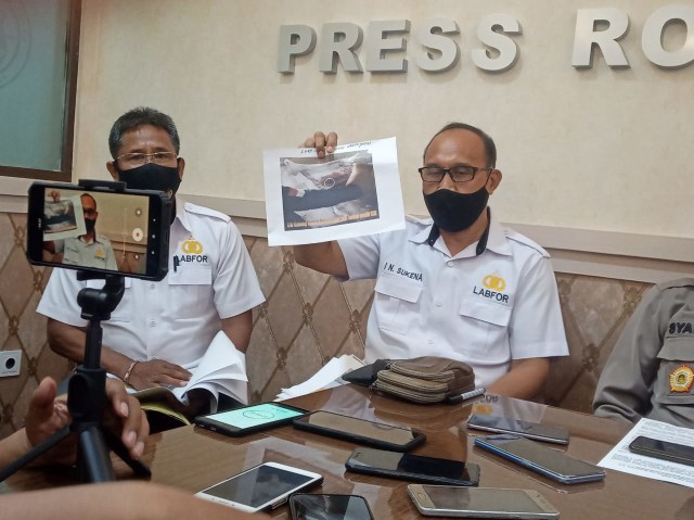 Petugas Labfor Polda Bali menunjukan gambar pistol yang digunakan Tri Nugraha bunuh diri - WIB