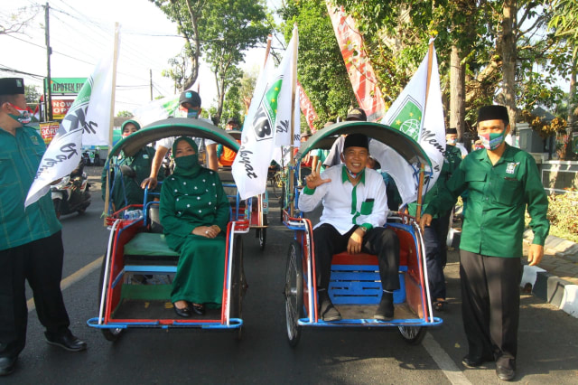 Pasangan Calon Bupati Malang Lathifah Shohib dan Didik Budi Muljono saat mendaftar ke KPU Kabupaten Malang menggunakan becak. foto: ben