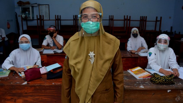 Guru berpose bersama siswanya usai kegiatan belajar mengajar (KMB) tatap muka terbatas di SMA Negeri 3, Kabupaten Jombang, Jawa Timur, Senin (7/9). Foto: Syaiful Arif/ANTARA FOTO