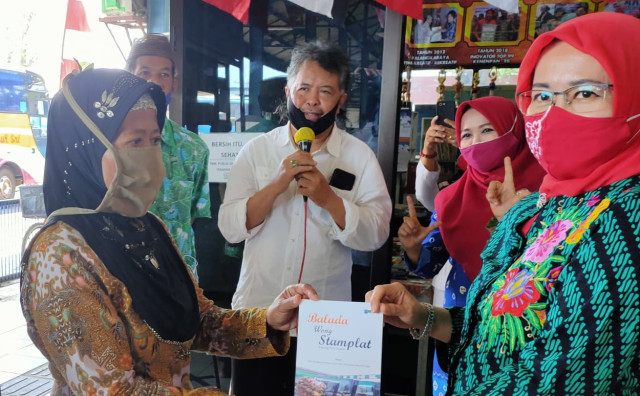 Salah satu pengasong menyerahkan buku antologi puisi kepada duta baca Kota Tegal pada peringatan Hari Literasi Internasional di TBM Sakila Kerti Komplek Terminal Bus Kota Tegal, Selasa (8/9/2020). (Foto: Setyadi)