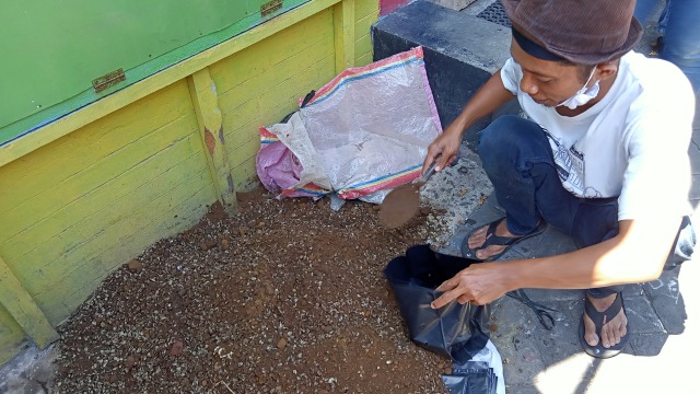 Jarwo memasukan campuran kulit ari dan tanah dalam polybag. Foto-foto: Masruroh/Basra﻿