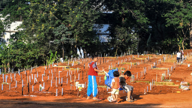 Sejumlah anak bermain di pemakaman jenazah COVID-19, di TPU Pondok Ranggon, Jakarta, Selasa (8/9/2020). Foto: Muhammad Adimaja/ANTARA FOTO