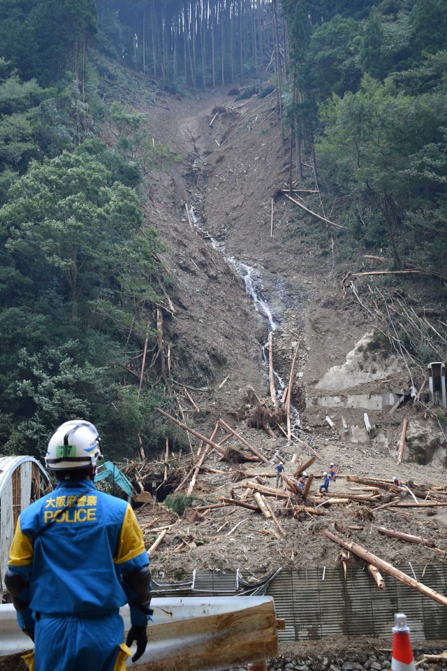 Polisi melakukan operasi pencarian dan penyelamatan di lokasi tanah longsor akibat Topan Haishen di desa Shiiba di Prefektur Miyazaki, Rabu (8/9). Foto: JIJI PRESS/AFP