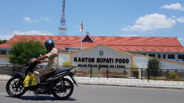 Seorang ASN tengah melintas di depan Kantor Bupati Poso, di Jalan Pulau Sumba, Kelurahan Gebangrejo, Kecamatan Poso Kota, Kabupaten Poso, Sulteng. Foto: Dok. PaluPoso