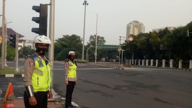 Petugas kepolisian memantau arus lalu lintas di Traffic Light Oteva arah Harmoni, Jakarta, Senin (14/9). 
 Foto: TMCPoldaMetro