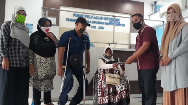 Zalsupran menyerahkan buku penduan terkait informasi publik kepada perwakilan disabilitas. Foto: Diskominsa Aceh