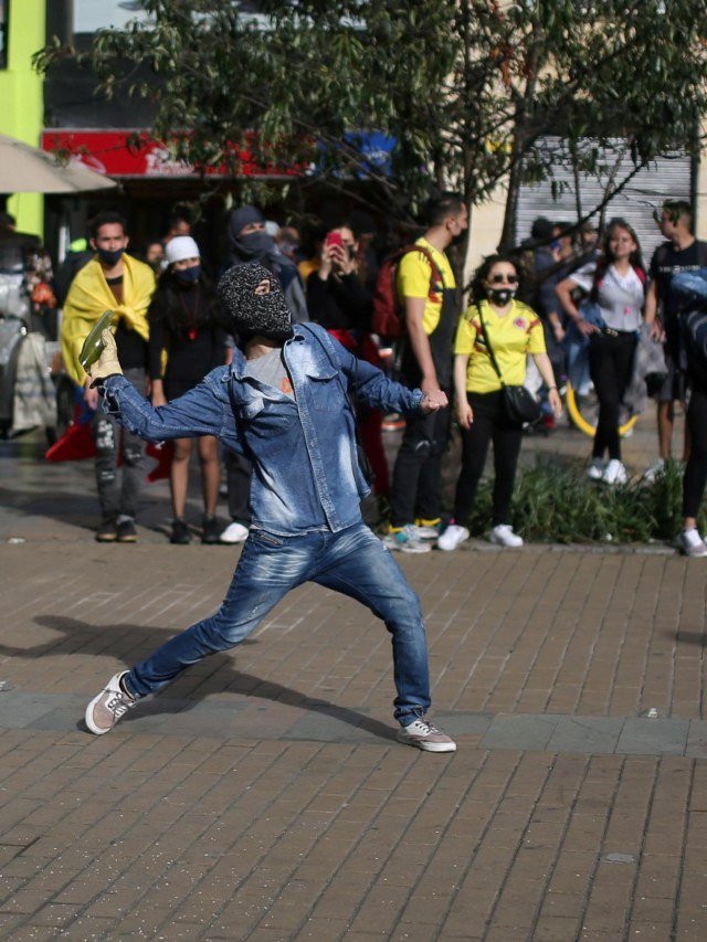 Seorang demonstran melempari polisi saat demonstrasi di Bogota, Kolombia, Minggu (13/9). Foto: Luisa Gonzalez/Reuters
