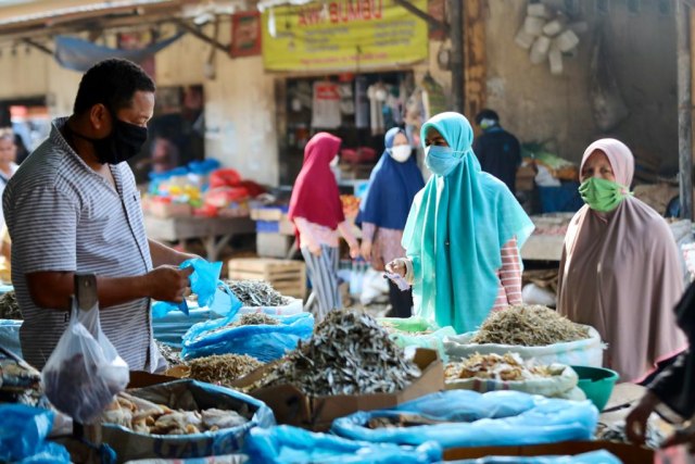 Warga Aceh memakai masker saat berbelanja kebutuhan dapur di pasar. Foto: Suparta/acehkini