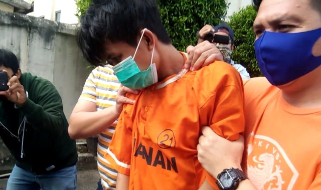 Tersangka Alpin Andrian (24) saat digelandang polisi untuk berpindah ruang pemeriksaan di Mapolresta Bandar Lampung, Rabu (16/9) | Foto: Obbie Fernando/Lampung Geh