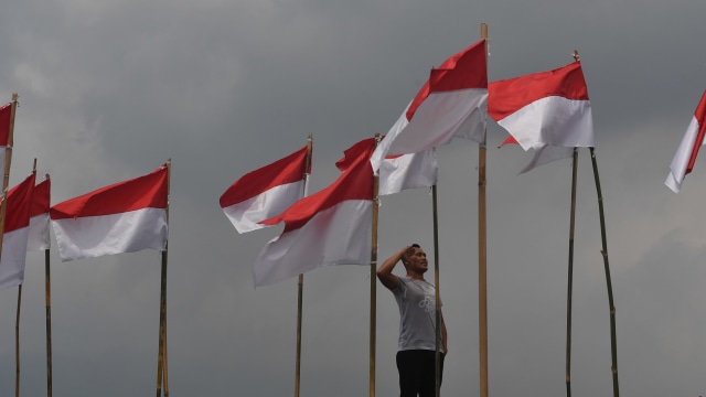 Seorang pengunjung memberi hormat ke bendera Merah Putih yang  dipasang di Poetoek Suko, Trawas, Mojokerto, Jawa Timur, Minggu (16/8/2020). Foto: Zabur Karuru/ANTARA FOTO