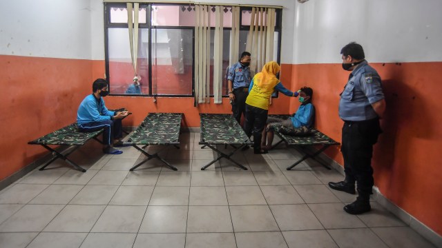 Petugas kesehatan memeriksa kondisi diduga warga dengan status Orang Tanpa Gejala (OTG) COVID-19 di ruang karantina, GOR Ciracas, Jakarta, Rabu (16/9).  Foto: Muhammad Adimaja/ANTARA FOTO