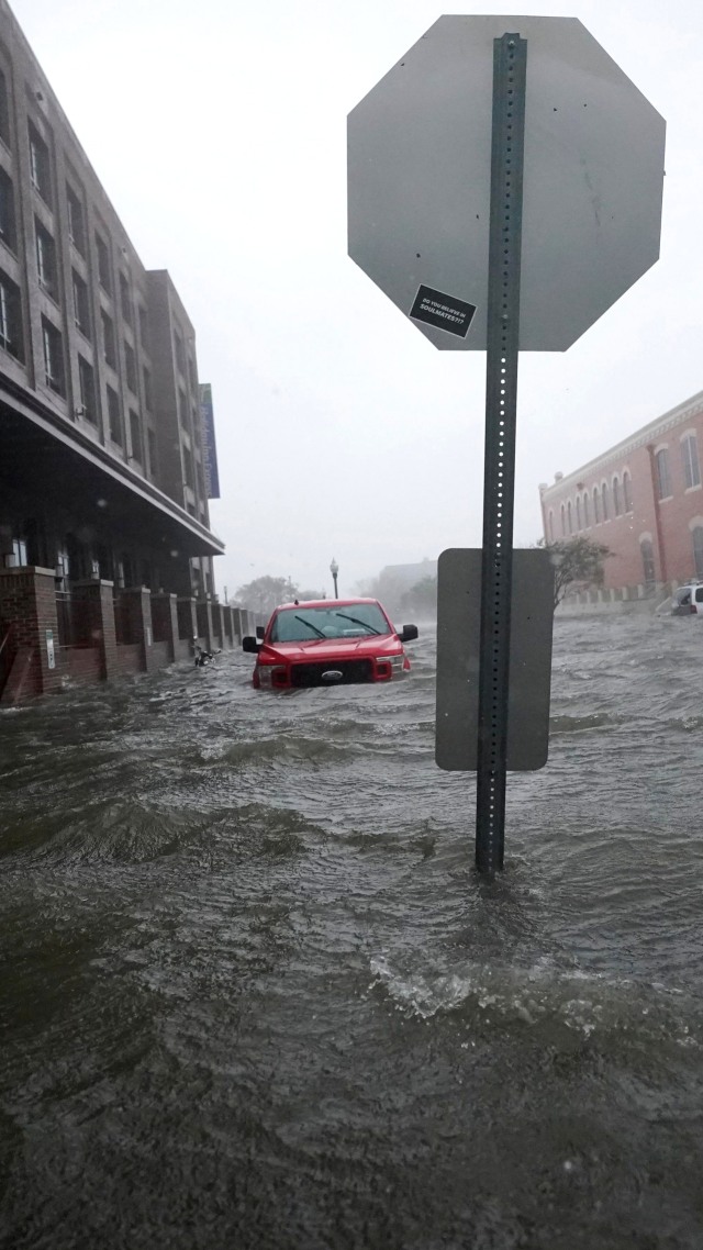 Mobil terendam banjir di pusat kota Pensacola, Florida, Amerika Serikat, Rabu (16/9). Foto: Gerald Herbert/AP Photo