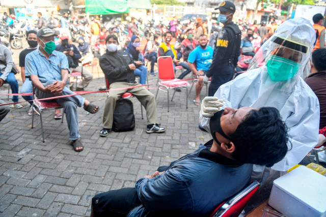 Suasana tes usap (swab test) COVID-19 pada warga di kawasan Pasar Keputran, Surabaya, Jawa Timur. Foto: M Risyal Hidayat/Antara Foto