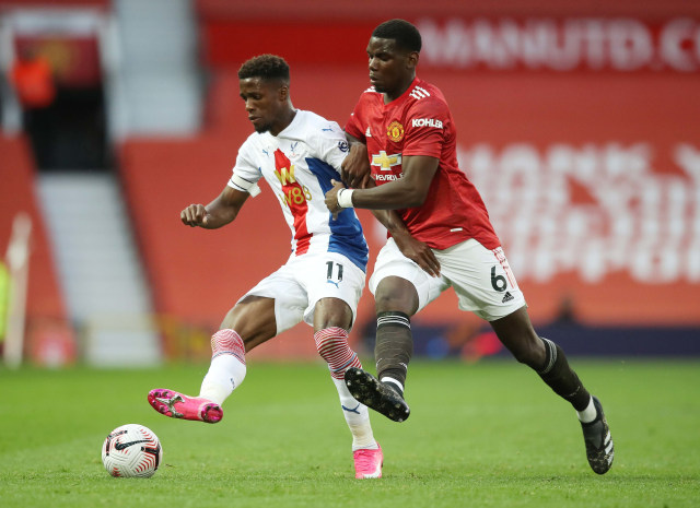 Penyerang Crystal Palace, Wilfried Zaha (kiri) saat berebut bola dengan Paul Pogba di Old Trafford, Manchester, Inggris. Foto: Martin Rickett /Reuters