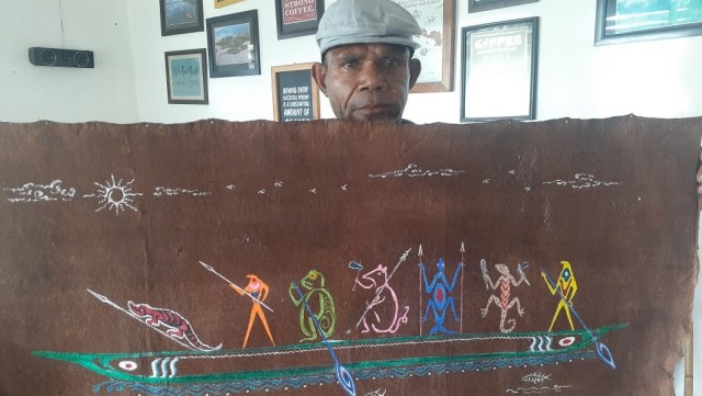 Corry Ohee, salah satu pelukis kulit kayu di Pulau Asei Sentani, Kabupaten Jayapura, memperlihatkan sebuah lukisan motif megalitik tutari. (Dok: Balai Arkeologi/Hari Suroto)