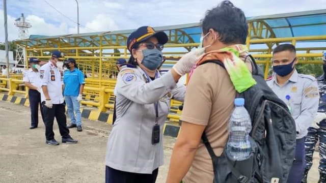 Pembagian masker ke penumpang kapal di Pelabuhan Penyeberangan Mamuju. Foto: Dok. Istimewa