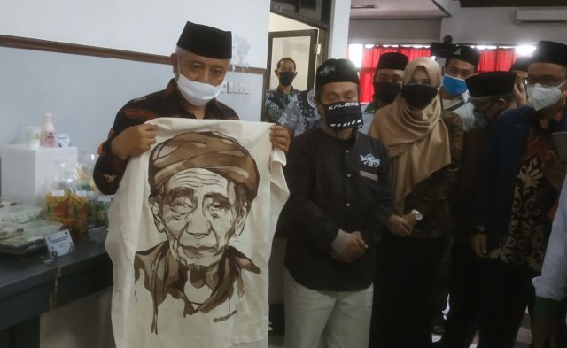 Bupati Malang Sanusi berfoto dengan Samsuddin, pemilik karya seni lukisan bordir berwajah karikatur Mbah Moen, di ajang pameran Workshop UMKM Kabupaten Malang, di Unisma, pada Minggu (20/9/2020). Foto: Ulul Azmy