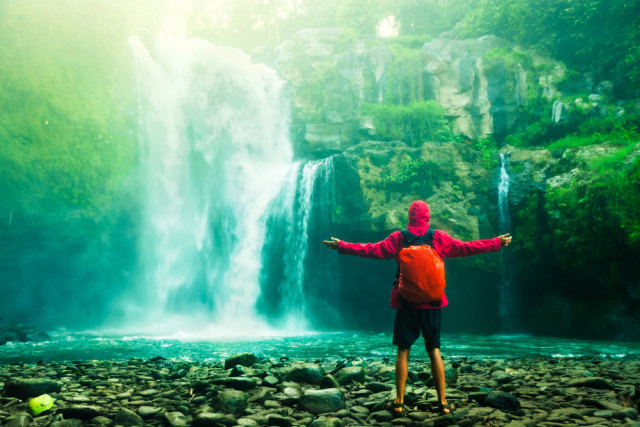 Ilustrasi wisatawan yang sedang menikmati indahnya air terjun. Foto: Shutterstock