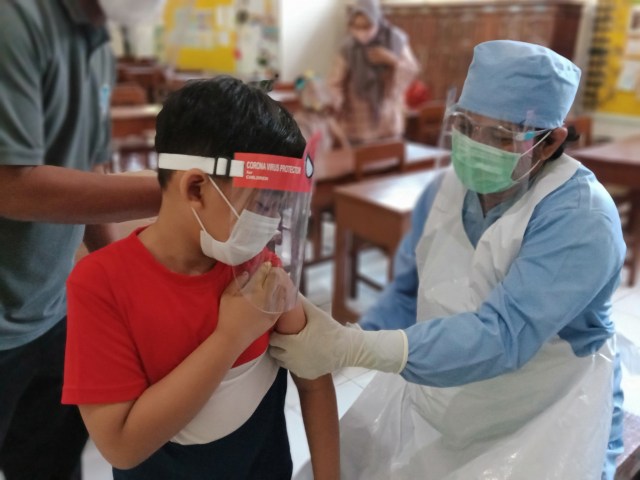 Sebanyak 100 siswa kelas 1 dari SD Muhammadiyah 1 Ketelan, Surakarta mengikuti kegiatan imunisasi yang dilangsungkan di tengah pandemi COVID-19, Senin (21/09)