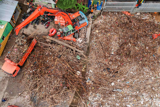 Foto aerial Petugas Dinas Kebersihan DKI Jakarta menggunakan alat berat membersihkan sampah di pintu air Manggarai, Jakarta, Selasa (22/9/2020). Foto: Galih Pradipta/Antara Foto