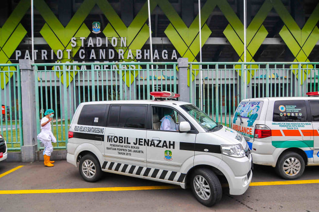 Sejumlah petugas medis menggunakan APD (Alat Pelindung Diri) memarkirkan  mobil ambulance usai menjemput pasien di Stadion Patriot Chandrabhaga, Bekasi, Jawa Barat, Selasa (22/9/2020). Foto: Fakhri Hermansyah/ANTARA FOTO