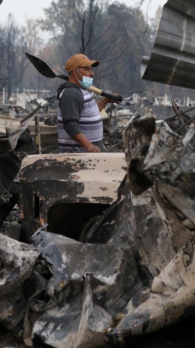 Seorang warga mencari barang untuk diselamatkan di sisa-sisa rumahnya yang terbakar di Phoenix, Oregon, AS, Selasa (22/9). Foto: Jim Urquhart/REUTERS