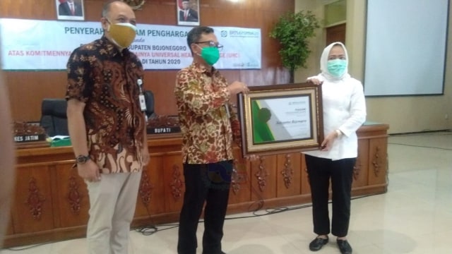 Bupati Bojonegoro, Dr Hj Anna Muawanah, saat terima Piagam penghargaan UHC, dari Kepala Divisi Regional (Divre) BPJS Jawa Timur.