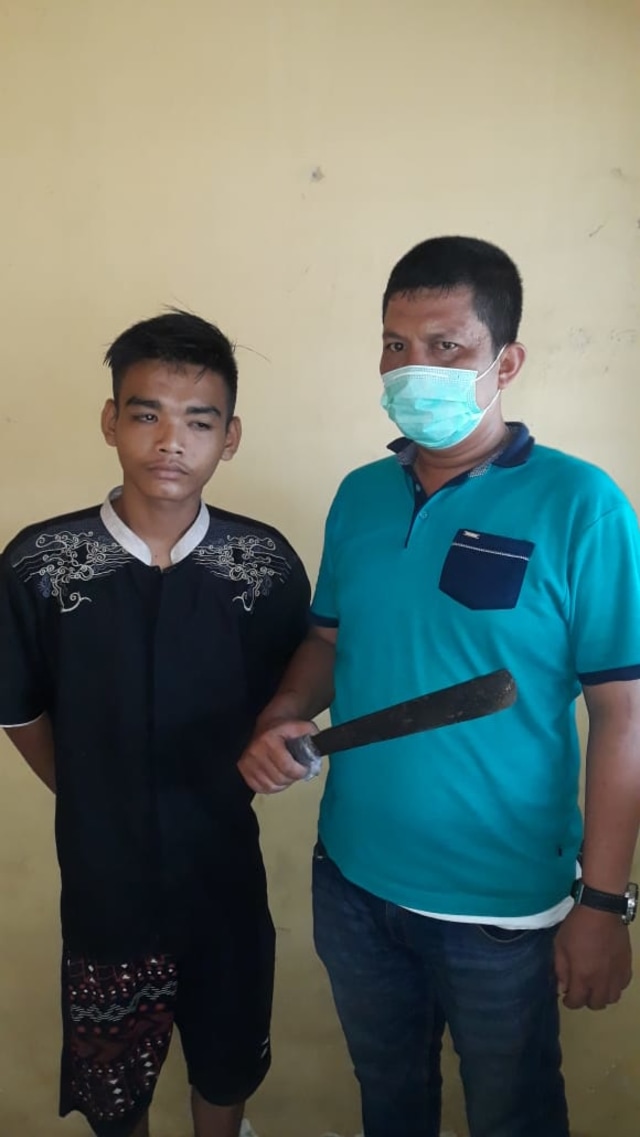 Tersangka Ahmad Fadli (kiri) saat diamankan polisi bersama barang bukti parang. Foto: Istimewa