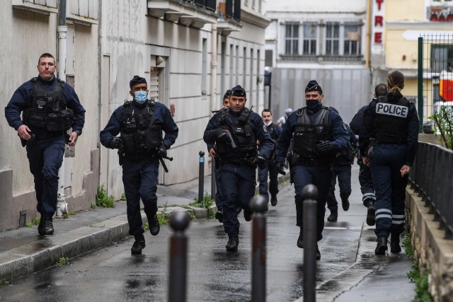 Petugas polisi Prancis bergegas ke tempat kejadian penyerangan di dekat bekas kantor majalah satir Prancis Charlie Hebdo di Paris, Prancis. Foto: Alain Jocard/AFP