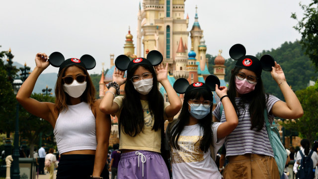 Pengunjung mengenakan masker foto bersama di Disneyland Hong Kong. Foto: Tyrone Siu,REUTERS