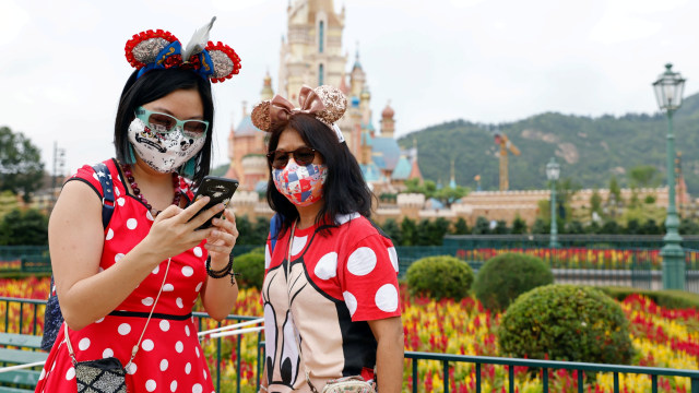 Pengunjung mengenakan masker swafoto di Disneyland Hong Kong yang kembali dibuka untuk umum di Hong Kong. Foto: Tyrone Siu,REUTERS