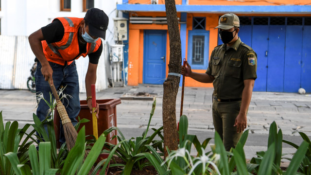 Warga yang melanggar aturan pemberlakuan Pembatasan Sosial Berskala Besar (PSBB) dihukum menyapu usai terjaring Operasi Tertib Masker di kawasan Kota Tua, Jakarta, Minggu (27/9).  Foto: Hafidz Mubarak A/ANTARA FOTO