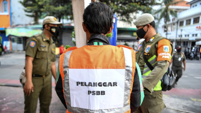 Warga yang melanggar aturan pemberlakuan Pembatasan Sosial Berskala Besar (PSBB) mengenakan rompi bertuliskan "Pelanggar PSBB" saat terjaring Operasi Tertib Masker di kawasan Kota Tua, Jakarta, Minggu (27/9). Foto: Hafidz Mubarak A/ANTARA FOTO