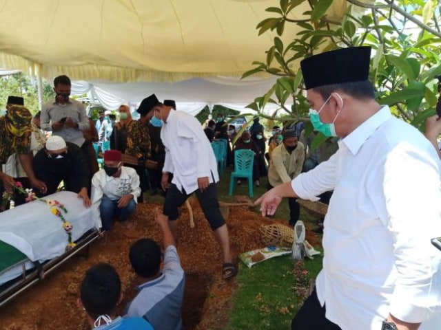 Ansar Ahmad dalam proses penguburan jenazah Nesar Ahmad di TPU Batu 25 Kijang, Kabupaten Bintan, Senin (28/9/2020). (Foto: Ary/Batamnews)