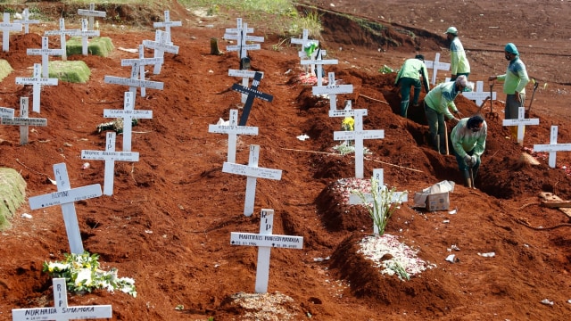 Pekerja menyiapkan kuburan baru di areal pemakaman umat Kristiani di kompleks pemakaman khusus jenazah COVID-19, di Pondok Ranggon di Jakarta. Foto: Ajeng Dinar Ulfiana/REUTERS