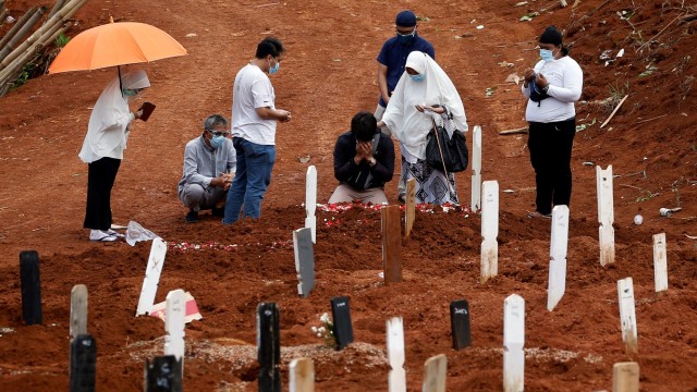 Sejumlah orang berduka saat pemakaman anggota keluarganya di kompleks pemakaman jenazah COVID-19, di Pondok Ranggon di Jakarta. Foto: Willy Kurniawan/REUTERS