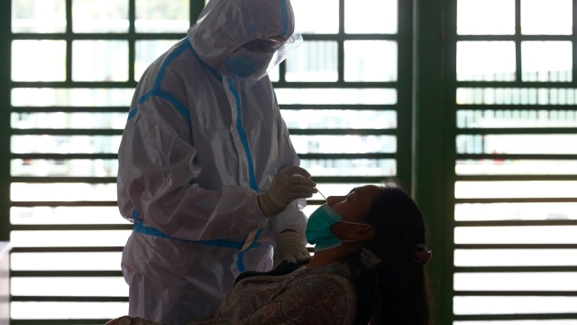 Petugas kesehatan yang mengenakan alat pelindung saat melakukan swab testi untuk penyakit virus korona (COVID-19) di Stadion Patriot Chandrabhaga, Bekasi. Foto: AJENG DINAR ULFIANA/REUTERS