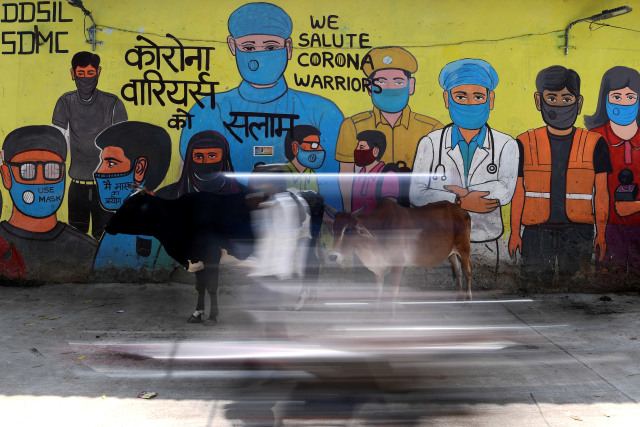 Mural yang menggambarkan pejuang garis depan virus corona yang digambar di dinding tempat pembuangan sampah di New Delhi, India. Foto: Sajjad Hussain/AFP