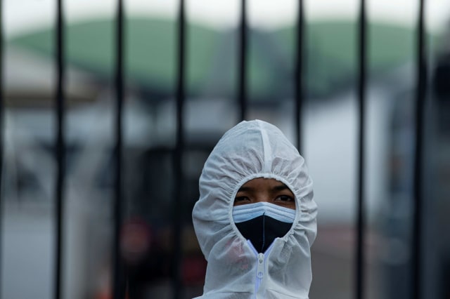 Polisi mengenakan masker dan pakaian hazmat saat mengamankan unjuk rasa penolakan buruh terhadap 'omnibus law' Rancangan Undang-Undangan (RUU) Cipta Kerja di depan kompleks Parlemen, Jakarta. Foto: Indrianto Eko Suwarso/Antara Foto