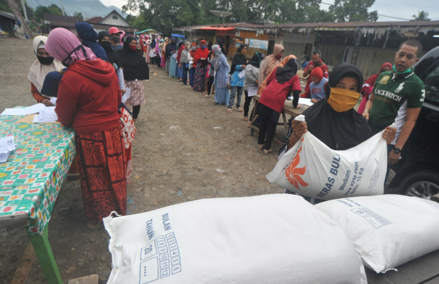 Sejumlah warga menerima bantuan beras di Nagari Kototangah Batu Hampa, Kabupaten Limapuluhkota, Sumatera Barat, Sabtu (26/9/2020). Foto: Iggoy el Fitra/ANTARA FOTO