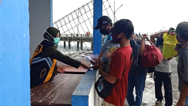 Seorang petugas dari kantor kesehatan pelabuhan (KKP) melakukan pemeriksaan dokumen kesehatan penumpang yang baru tiba di pelabuhan Haji Hayun Tolitoli, Sulteng Foto: Moh. Sabran/PaluPoso