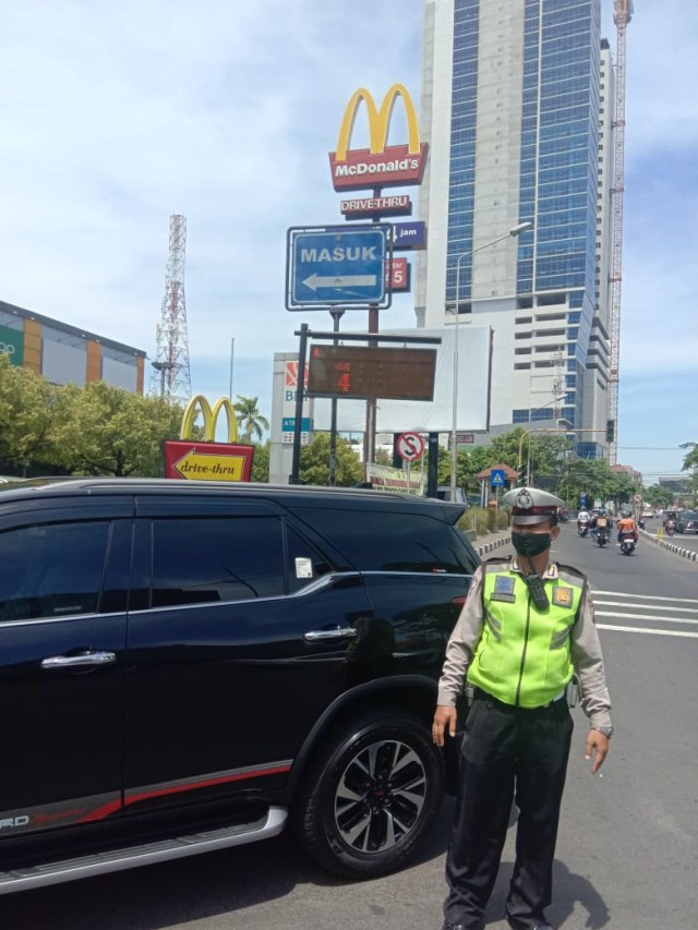 Polisi mengatur lalu lintas pengendara yang ingin drive thru di McD Plaza Marina, Wonocolo, Surabaya.  Foto: Dok. Satlantas Polrestabes Surabaya