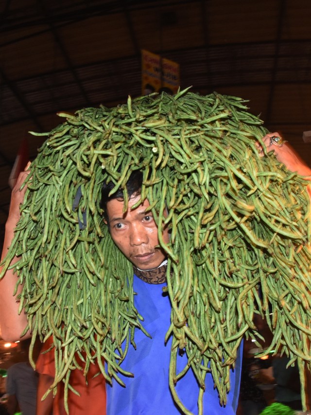 Juru angkut memanggul sayur tanpa menggunakan masker di Pasar Induk Kramat Jati, Jakarta, Kamis (1/10). Foto: Indrianto Eko Suwarso/ANTARA FOTO