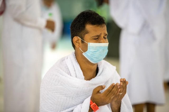 Seorang jemaah mengenakan masker berdoa saat melaksanakan umrah di Masjidil Haram, Makkah, Arab Saudi. Foto: Dok. gph.gov.sa